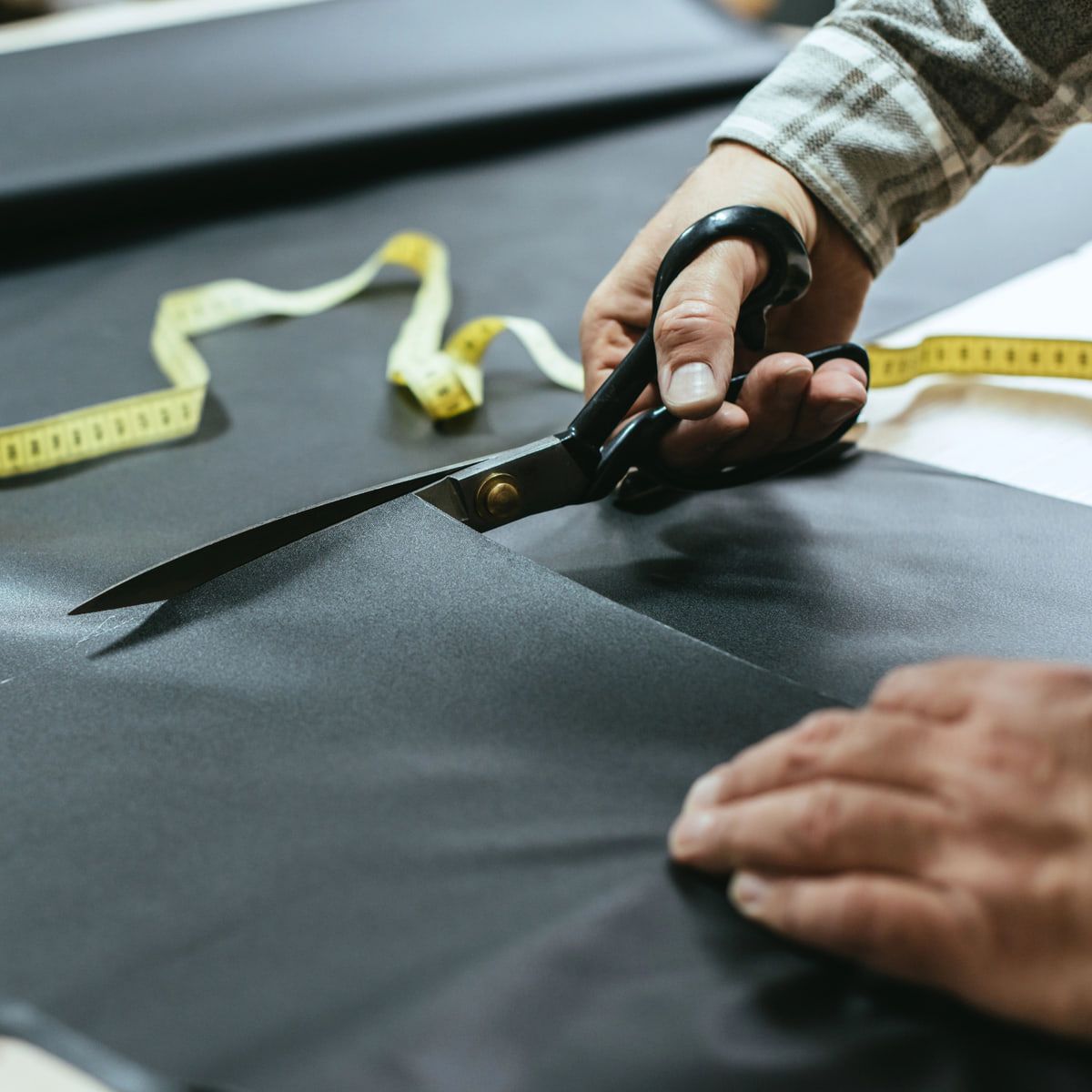 Corte de tecido com tesoura sobre a mesa